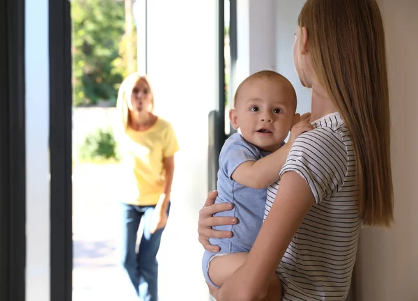 La madre lascia il suo bambino con la tata adolescente a casa. Spazio per testo — Foto Stock