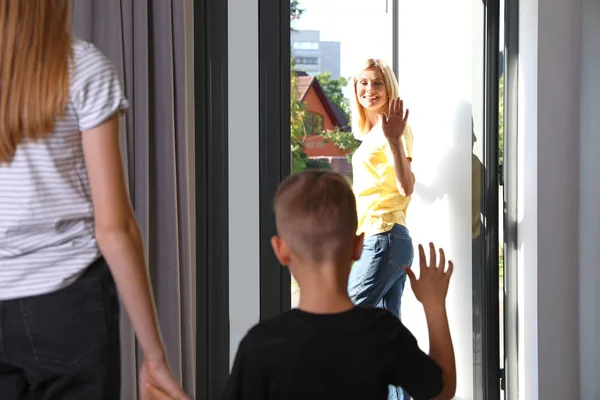 Mother leaving her little son with teen nanny at home — Stock Photo, Image