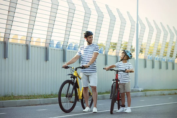 Тато і син катаються на велосипедах на стадіоні — стокове фото