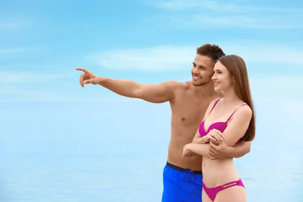 Mujer joven en bikini con su novio en la playa. Hermosa pareja. — Foto de Stock