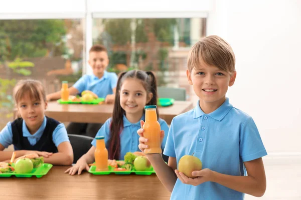 학교 식당에서 주스와 사과 병을 들고 행복한 소년. 건강한 음식 — 스톡 사진