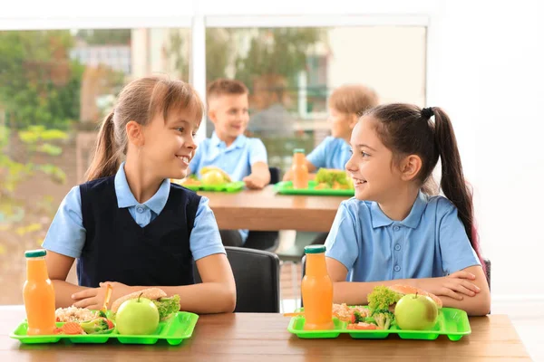 Ευτυχισμένα κορίτσια στο τραπέζι με υγιεινό φαγητό στο σχολικό κυλικείο — Φωτογραφία Αρχείου