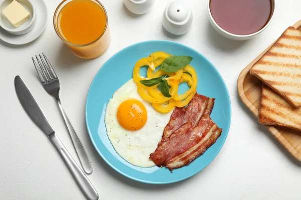 Leckeres Frühstück mit Spiegelei auf hellem Tisch serviert, flach gelegt — Stockfoto