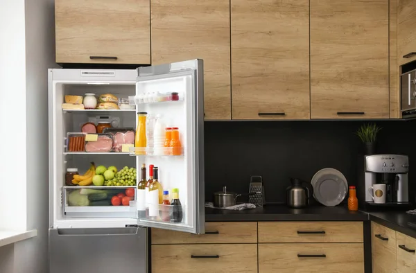 Refrigerador abierto lleno de productos en la cocina — Foto de Stock