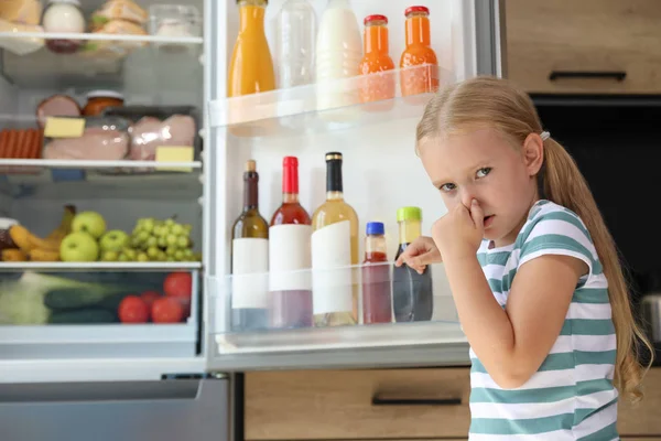 Girl feeling bad smell from stale products in refrigerator at home — Stock Photo, Image
