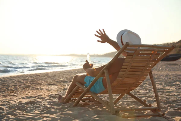 年轻人在海边的海滩上的躺椅上放松 — 图库照片