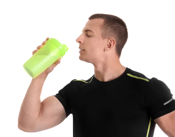 Atlético jovem bebendo batido de proteína no fundo branco — Fotografia de Stock