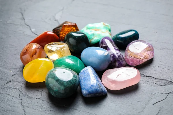 Pilha de diferentes pedras preciosas na mesa cinza — Fotografia de Stock