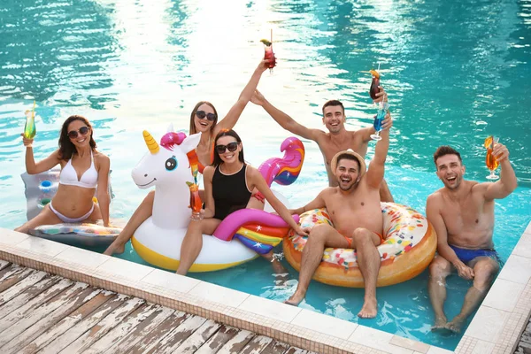 Ευτυχισμένοι νέοι φίλοι με δροσιστικά κοκτέιλ χαλαρώνοντας στην πισίνα — Φωτογραφία Αρχείου