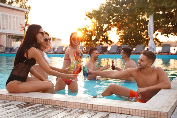 Felices jóvenes amigos con refrescantes cócteles relajantes en la piscina — Foto de Stock