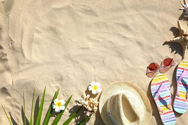 Composición plana con diferentes accesorios de playa sobre arena. Espacio para texto — Foto de Stock