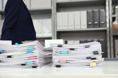 Ofis masasında kağıt kliplere sahip belgelerin yığınları