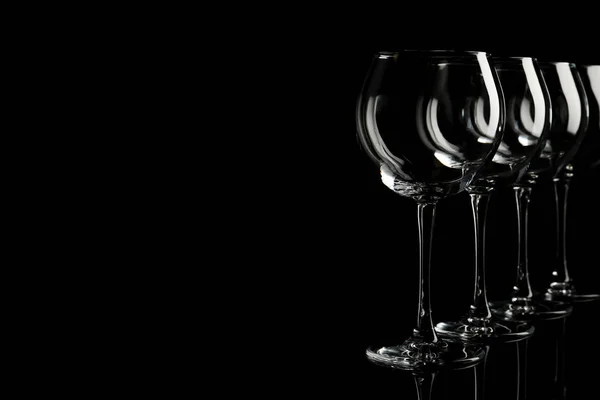 Conjunto de copos de vinho vazios no fundo preto. Espaço para texto — Fotografia de Stock