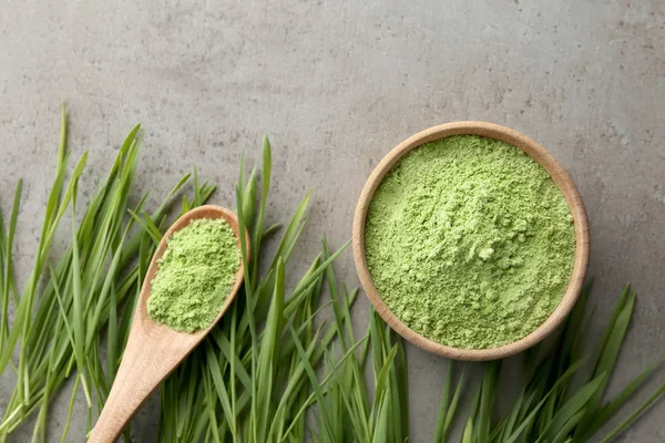 Platte lay compositie met tarwegras en spruiten op een grijze tafel — Stockfoto