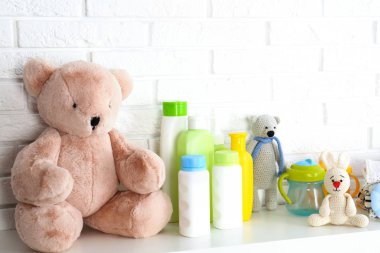 Beyaz tuğla duvar a yakın rafta Bebek aksesuarları