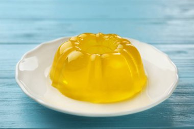 Mavi ahşap masa üzerinde lezzetli meyve jöle tabak, closeup