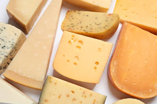 Composición con diferentes tipos de queso sabroso sobre fondo blanco, vista superior — Foto de Stock