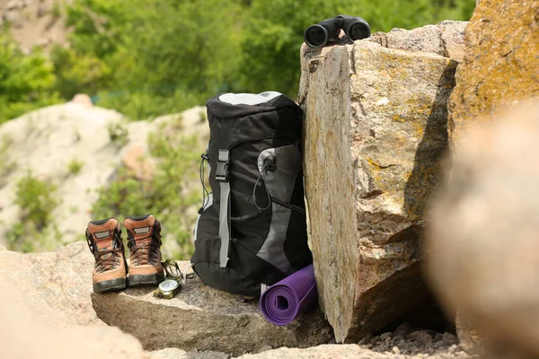 Backpack and camping equipment on rocks in wilderness