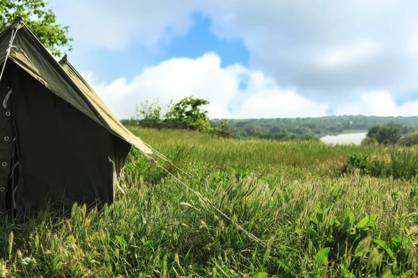 Kemping sátor, zöld mezőben napsütéses napon. Szóköz a szöveghez — Stock Fotó