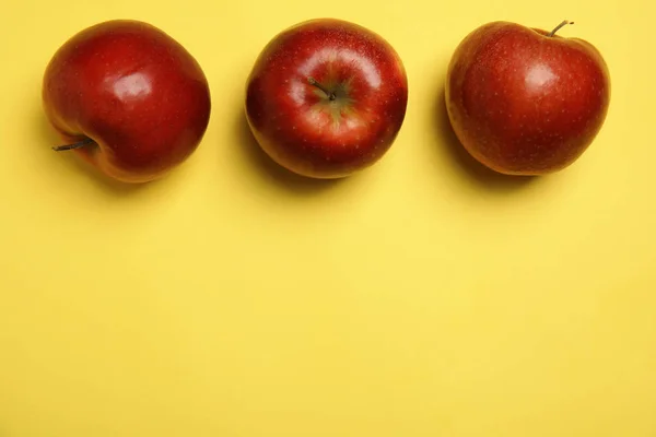 Composición plana con manzanas rojas jugosas maduras sobre fondo amarillo, espacio para texto — Foto de Stock
