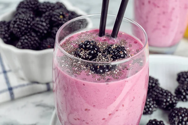 Delicioso batido de mora en vidrio sobre mesa de mármol, primer plano —  Fotos de Stock