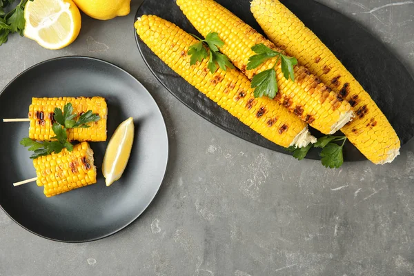 Composición plana de mazorcas de maíz a la parrilla sobre mesa gris — Foto de Stock