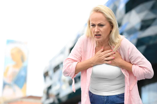 Érett nő szenved szívinfarktus szabadban. Szóköz a szöveghez — Stock Fotó