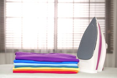 Modern elektrikli demir ve kapalı gemide katlanmış giysiler. Metin için alan