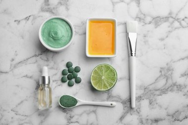 Mermer masa üzerinde spirulina yüz maskesi ve malzemeler ile düz yatıyordu kompozisyon