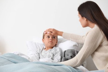 Anne yatakta soğuk muzdarip küçük oğlu bakımı, metin için alan