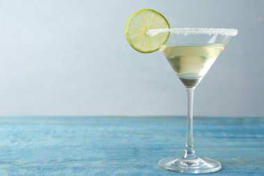 Açık mavi ahşap masa üzerinde Kireç Damla Martini kokteyl Cam. Metin için alan