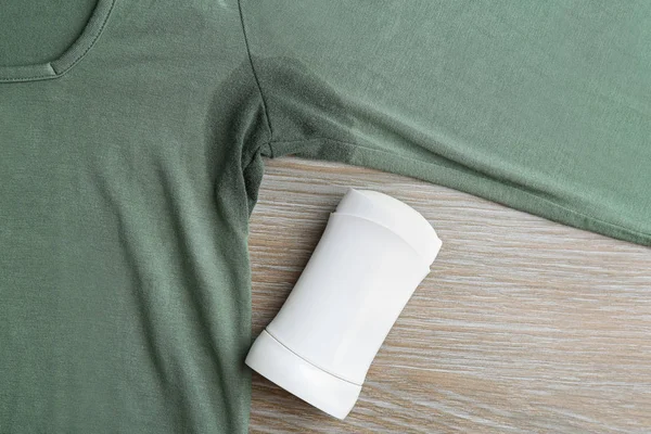 Kleding met vlek en deodorant op houten achtergrond, bovenaanzicht — Stockfoto