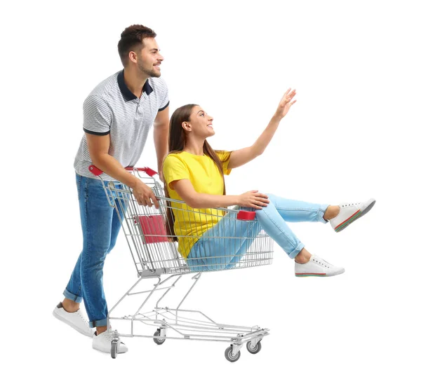 Casal jovem com carrinho de compras no fundo branco — Fotografia de Stock