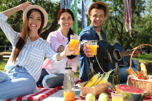 Young people enjoying picnic in park on summer day