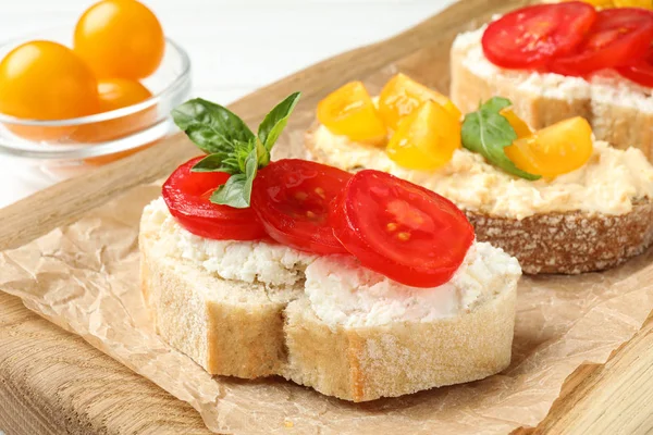 Tasty fresh tomato bruschettas on wooden board, closeup — Stock Photo, Image