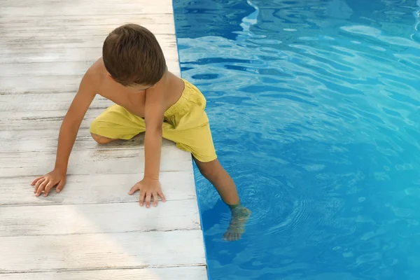 Niño pequeño cerca de la piscina al aire libre. Situación peligrosa — Foto de Stock