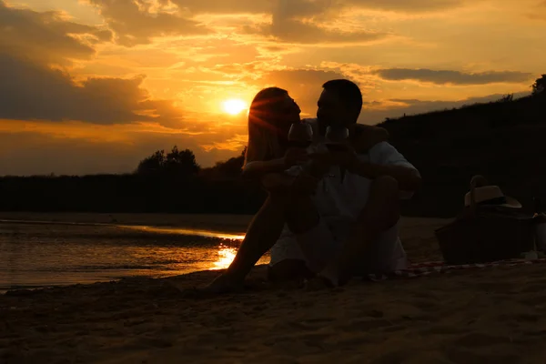 Χαρούμενο ρομαντικό ζευγάρι πίνοντας κρασί μαζί στην παραλία — Φωτογραφία Αρχείου