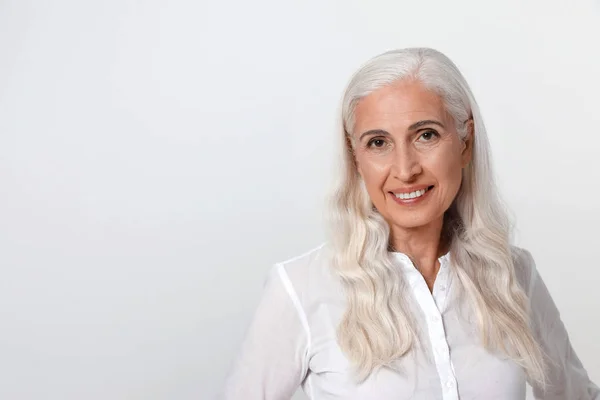 Retrato de bela mulher madura no fundo de luz, espaço para texto — Fotografia de Stock