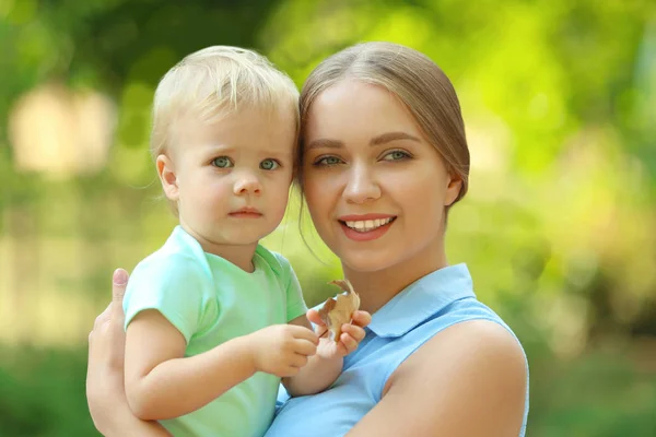 Junge Mutter mit ihrem süßen Kind im grünen Park — Stockfoto