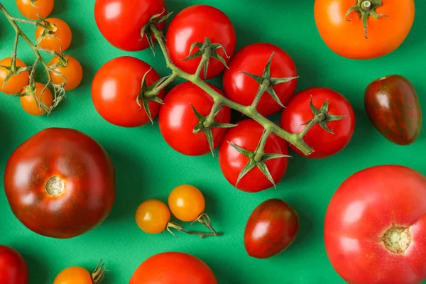Composición plana con tomates maduros frescos sobre fondo verde —  Fotos de Stock