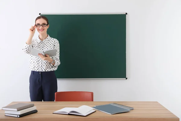 Portrait of young female teacher in classroom — Stock Photo, Image