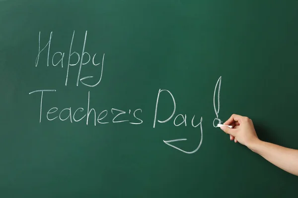 Woman writing HAPPY TEACHER\'S DAY on green chalkboard, closeup view
