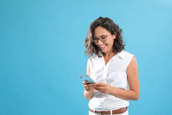 Glückliche junge Frau mit Smartphone auf blauem Hintergrund. Raum für Text — Stockfoto