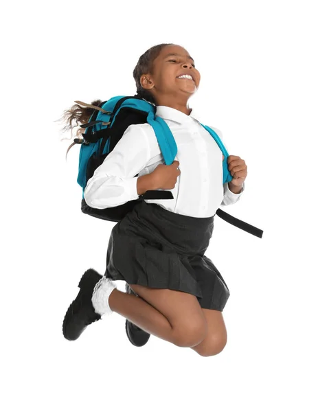 Feliz chica afroamericana en uniforme escolar saltando sobre fondo blanco — Foto de Stock
