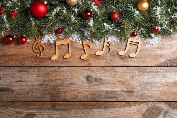 Płaska kompozycja z dekorem świątecznymi i nutami muzycznymi na drewnianym stole, miejsce na tekst — Zdjęcie stockowe