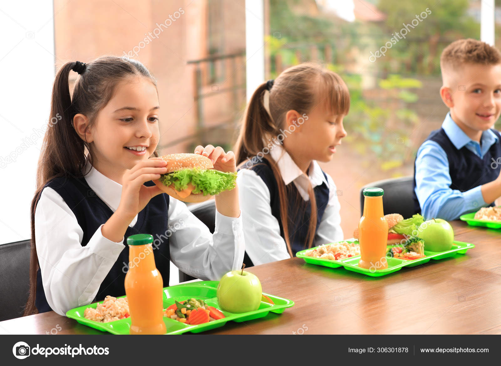 Happy children at table with healthy food in school canteen Stock Photo by  ©NewAfrica 306301878