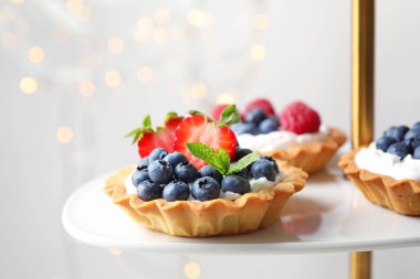 Kek standında farklı çilek ile Tarts. Lezzetli hamur işleri