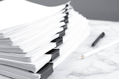 Mermer masa üzerinde bağlayıcı klipsli belge yığını, yakın çekim