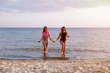 Sahilde kız arkadaşı ile bikini genç kadın. Güzel çift