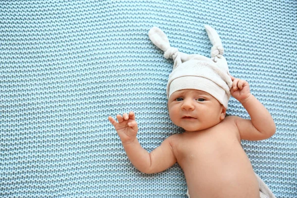 Lindo bebé con sombrero acostado en cuadros de color azul claro, vista superior. Espacio para texto — Foto de Stock